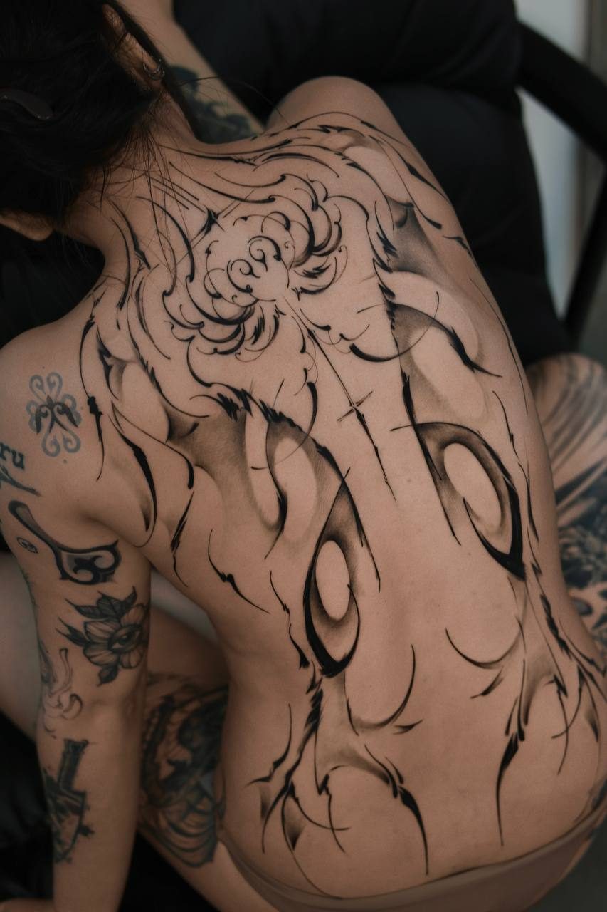 Flowing freehand back-piece of brushstroke linework